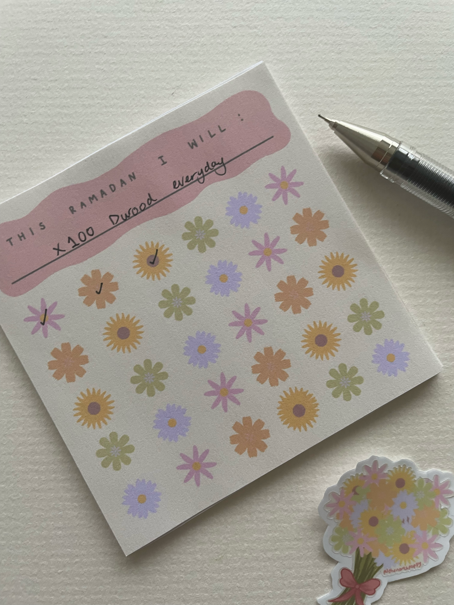 Notebook with floral stickers and a pen on a light surface