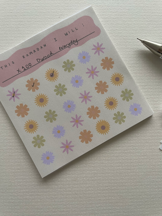 Notebook with floral stickers on a plain background