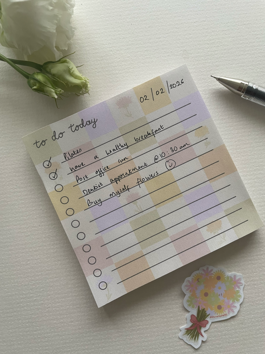 Note pad with checklists and a pen on a light surface